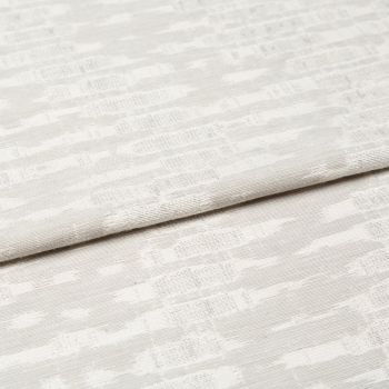 Off-white woven curtain fabric folded horizontally, showing a subtle geometric jacquard pattern; soft, diffused light highlights the texture in a neutral, close-up interior view.
