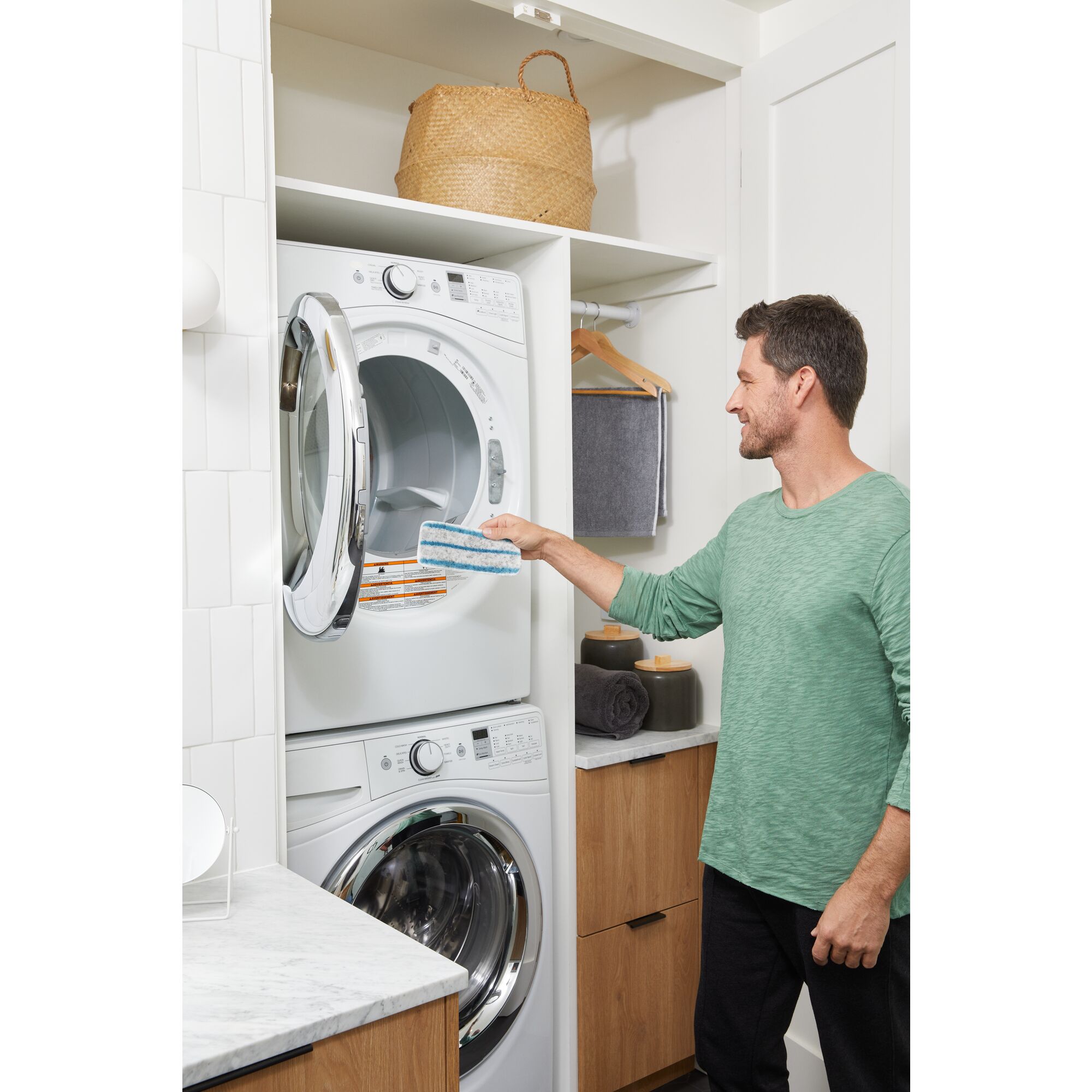 Man tossing the removable steam mop head cleaning pad into a washing machine