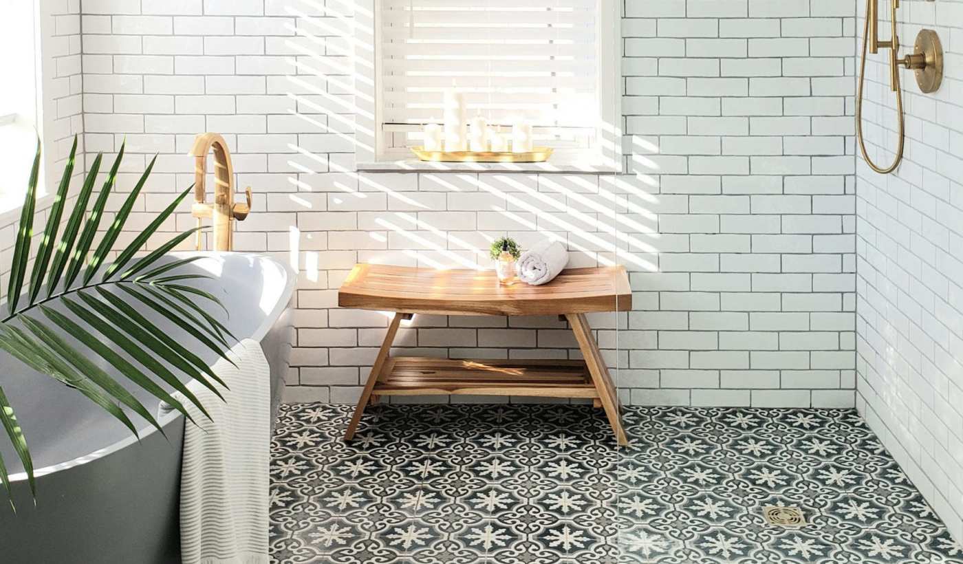 a bathroom with black and white tile and a plant.