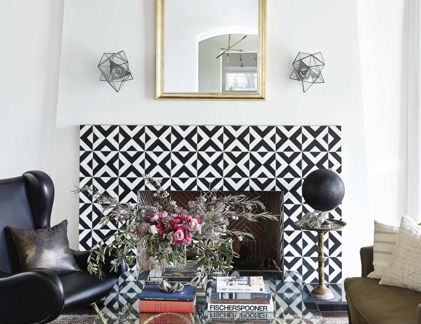 a living room with a black and white tiled fireplace.