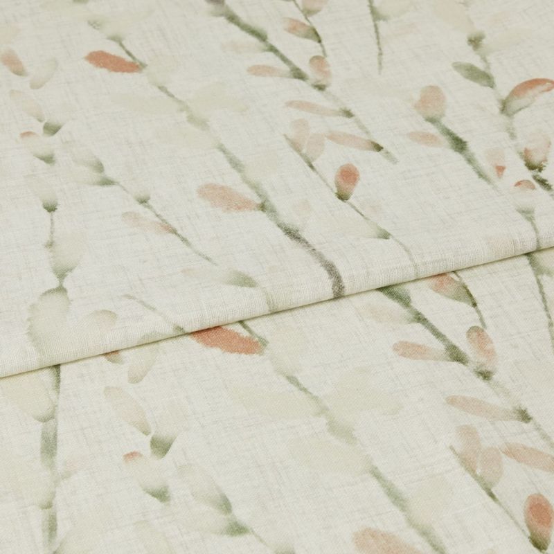 Cream linen-look curtain fabric with soft green stems and peach buds, folded across the frame, overlapping at the center; close-up view with gentle, diffuse lighting showing woven texture.