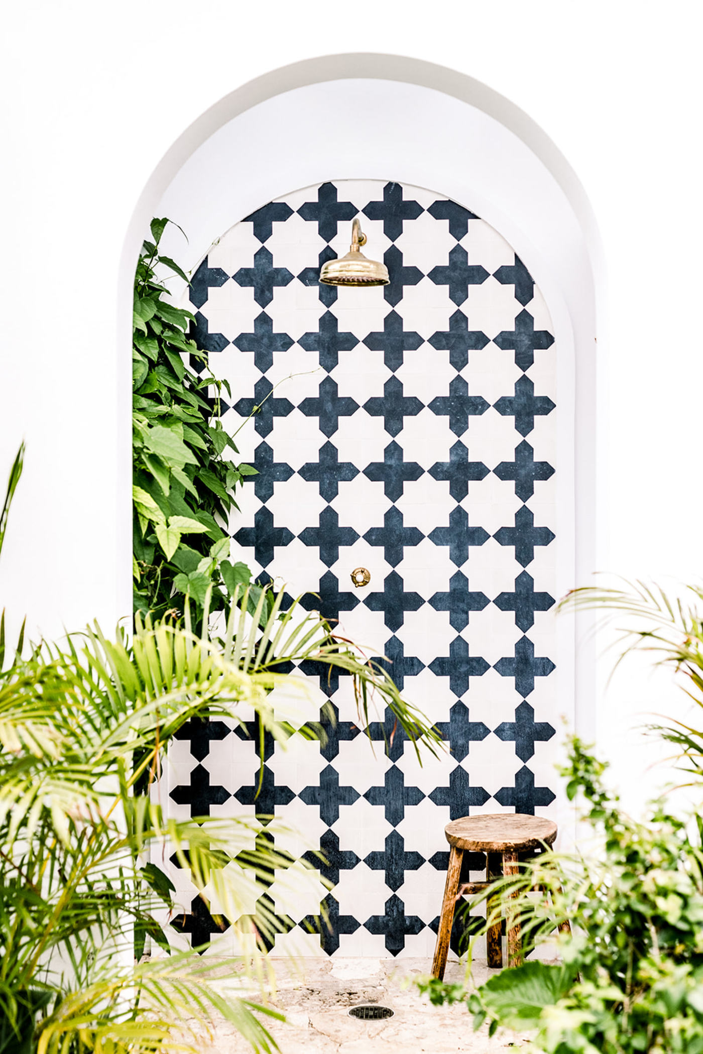 a bathroom with a black and white tiled shower.