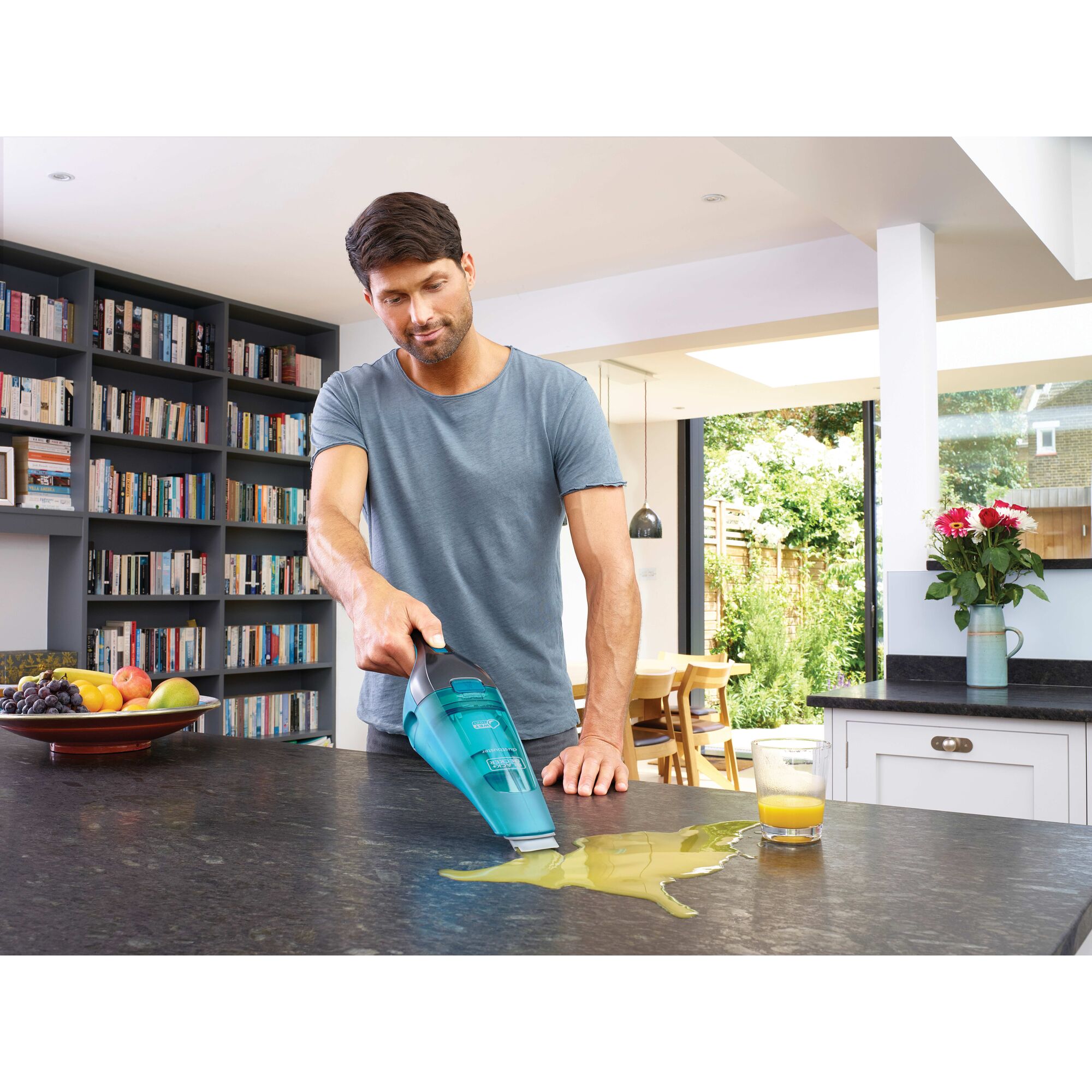 Dustbuster QuickClean Cordless Hand Vacuum Wet or Dry being used by person to clean spilled juice from countertop.
