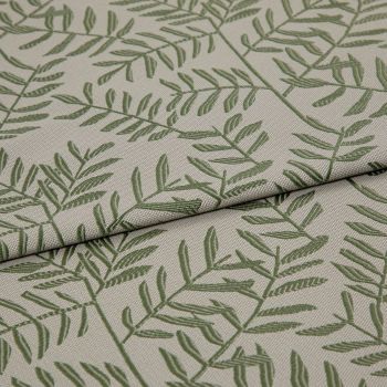 Beige woven fabric panel printed with green fern-like branches (textured weave) — lying with two overlapping folds — close-up on a neutral surface under soft, even lighting.
