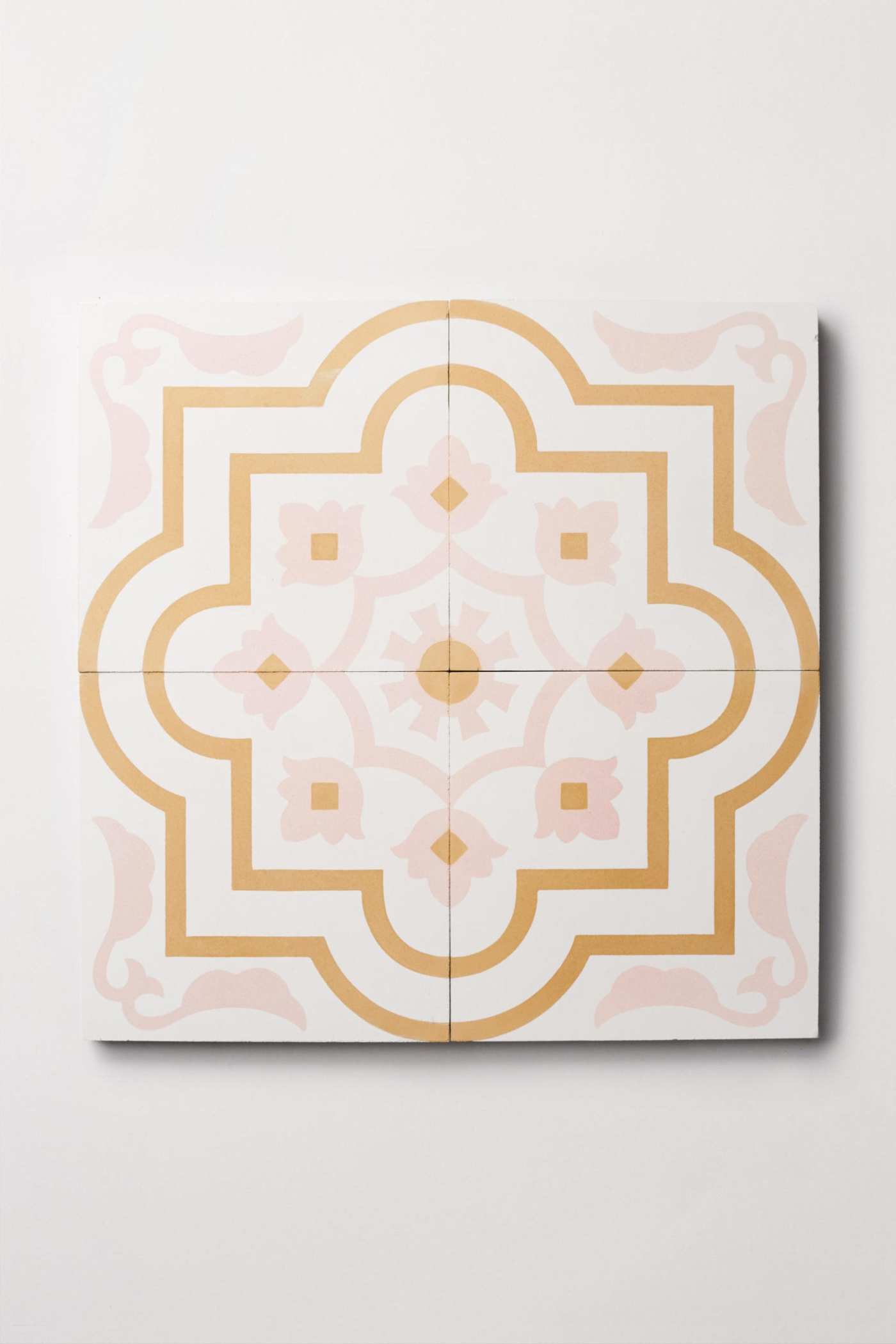 four tiles with pink and gold designs on them.