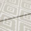 Folded woven upholstery fabric with beige-and-white diamond Aztec-style pattern, folded diagonally across the frame; crisp texture visible, photographed in soft, even studio lighting as a close-up.
