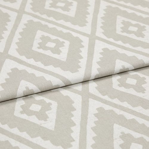 Folded woven upholstery fabric with beige-and-white diamond Aztec-style pattern, folded diagonally across the frame; crisp texture visible, photographed in soft, even studio lighting as a close-up.