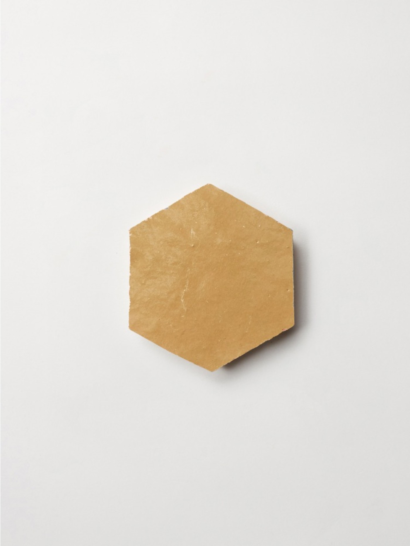 a yellow hexagonal tile on a white surface.