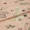 Pink woven fabric printed with red-crowned cranes and stylized trees â€” folded to show layered panels â€” close-up on a soft textile surface under soft, even lighting.