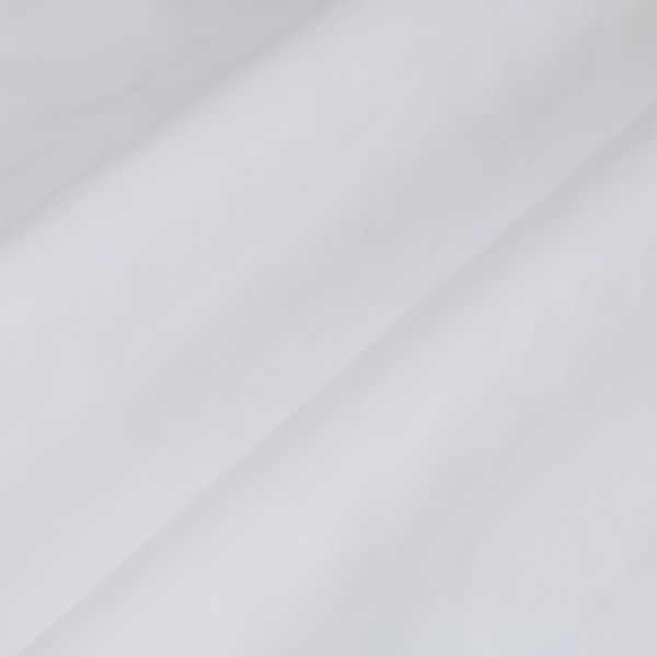 White fabric with a prominent diagonal fold, draped smoothly across the frame showing soft creases; close-up view under diffuse, neutral lighting with no visible surroundings.