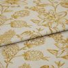 Cream fabric with mustard-gold botanical print, folded and overlapped to reveal panels; studio-lit close-up showing woven texture and repeating floral pattern.