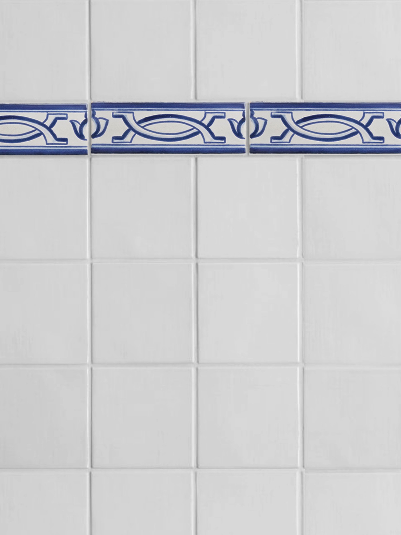 a blue and white tiled bathroom with a blue border pattern.