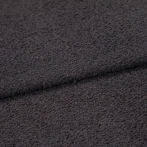 Dark charcoal looped fabric, forming a shallow horizontal fold, close-up studio view emphasizing coarse, pebble-like texture under even, neutral lighting.
