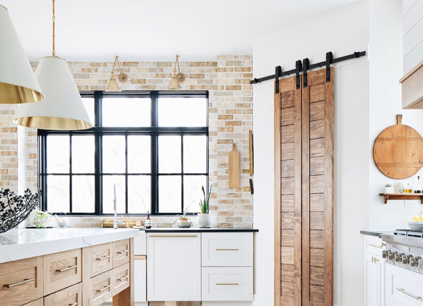 a white kitchen with a wooden barn door.