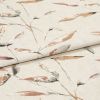 Beige linen-like fabric with muted watercolor leaf pattern, folded over itself creating a horizontal crease; displayed as a studio close-up with soft, even lighting.