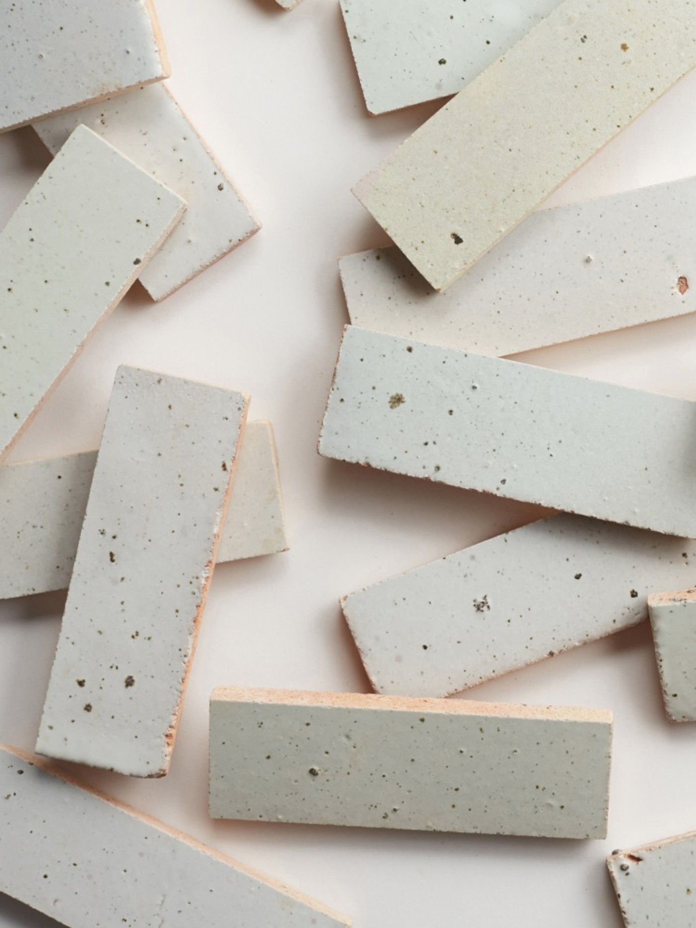 a group of white and grey tiles with speckles scattered across a white surface.