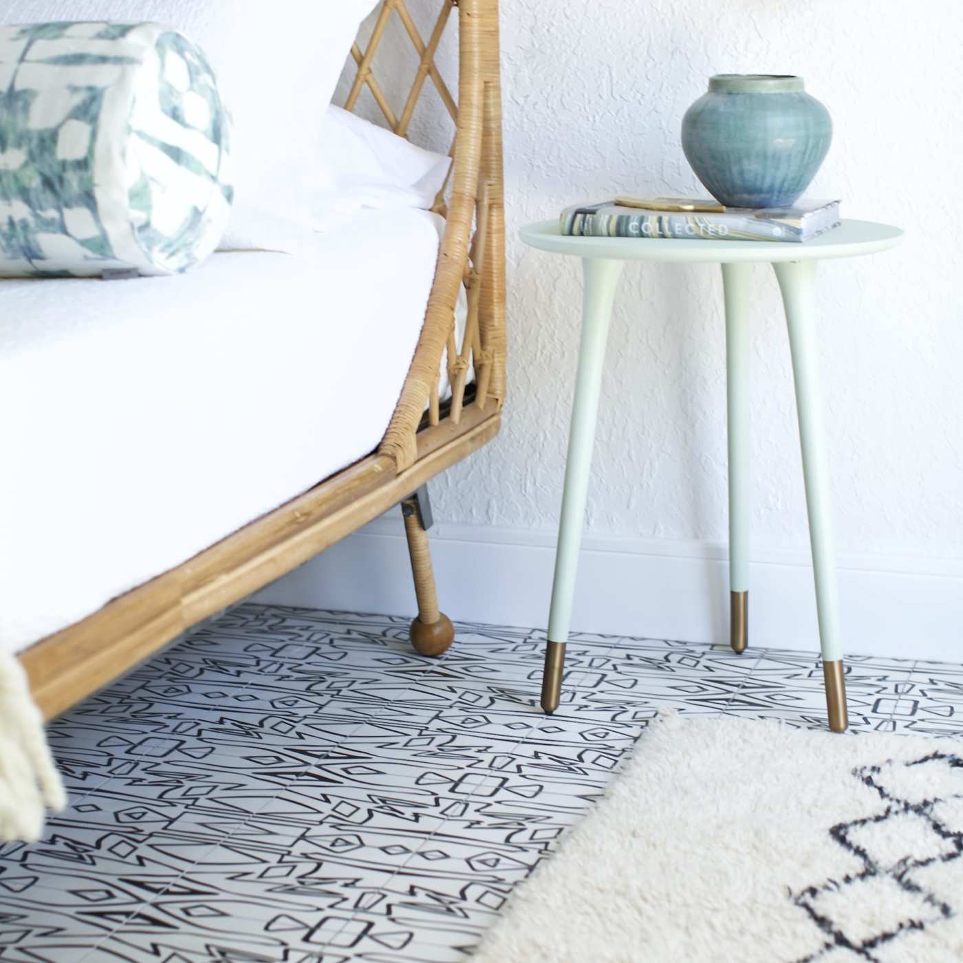 a bed with a wicker side table and a lamp.