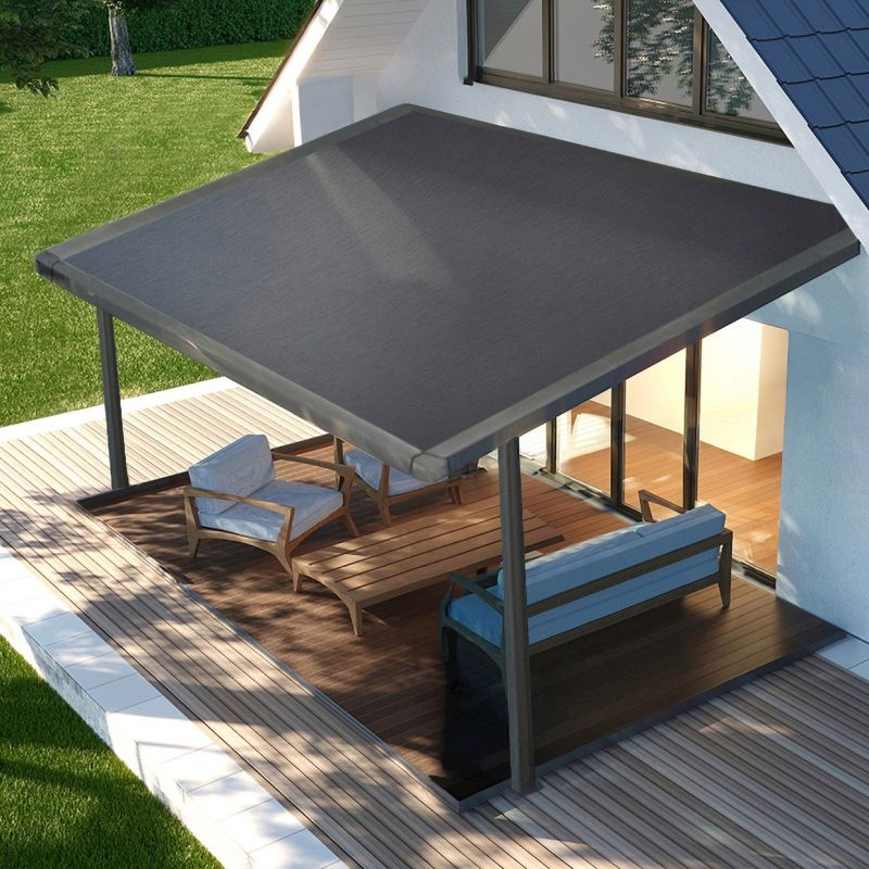 Dark gray fabric awning, rectangular and extended from the house on metal posts, shading a wooden deck patio with lounge chairs beside sliding glass doors, daytime sunlight and a grassy lawn.