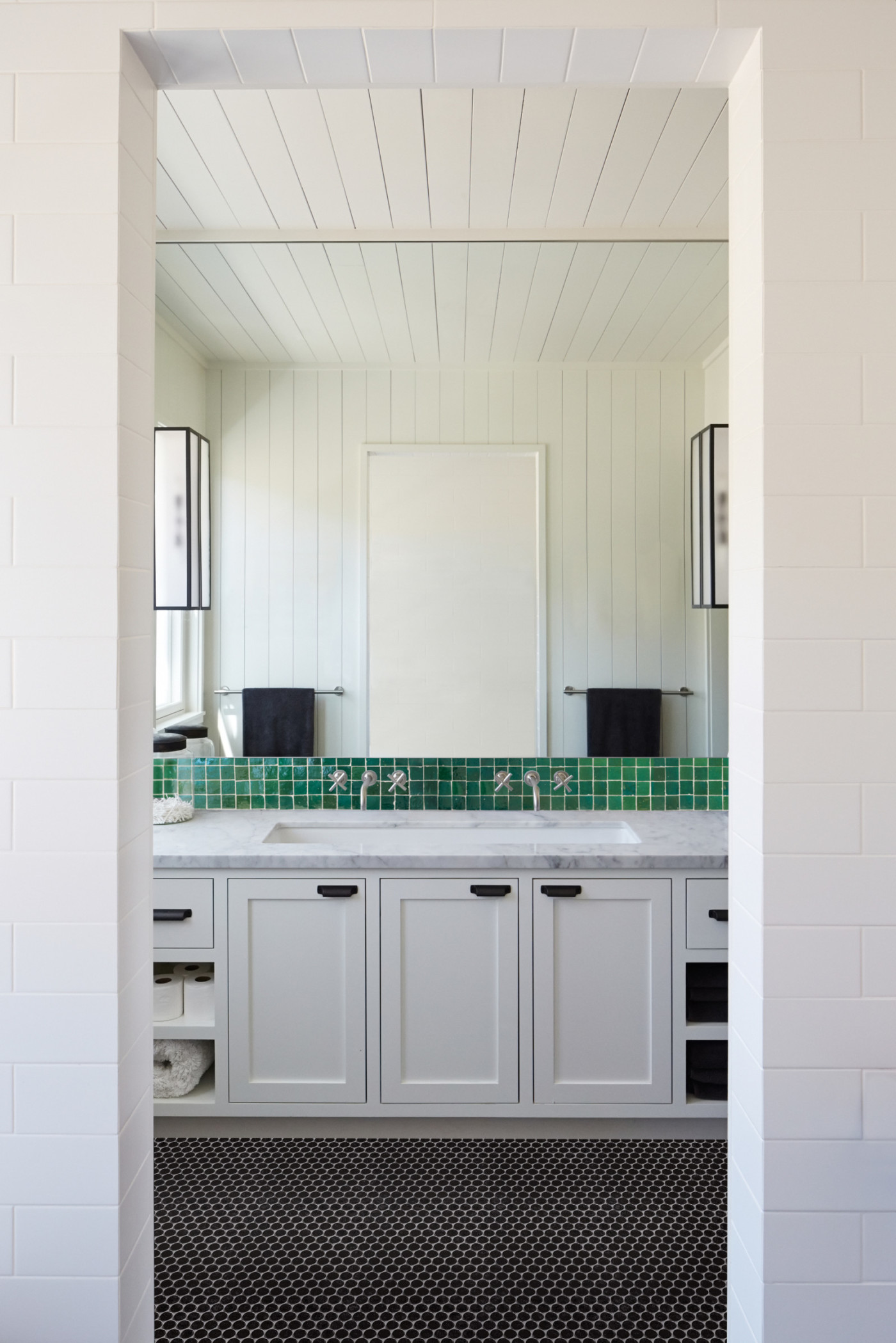 a white bathroom with a green tiled floor.