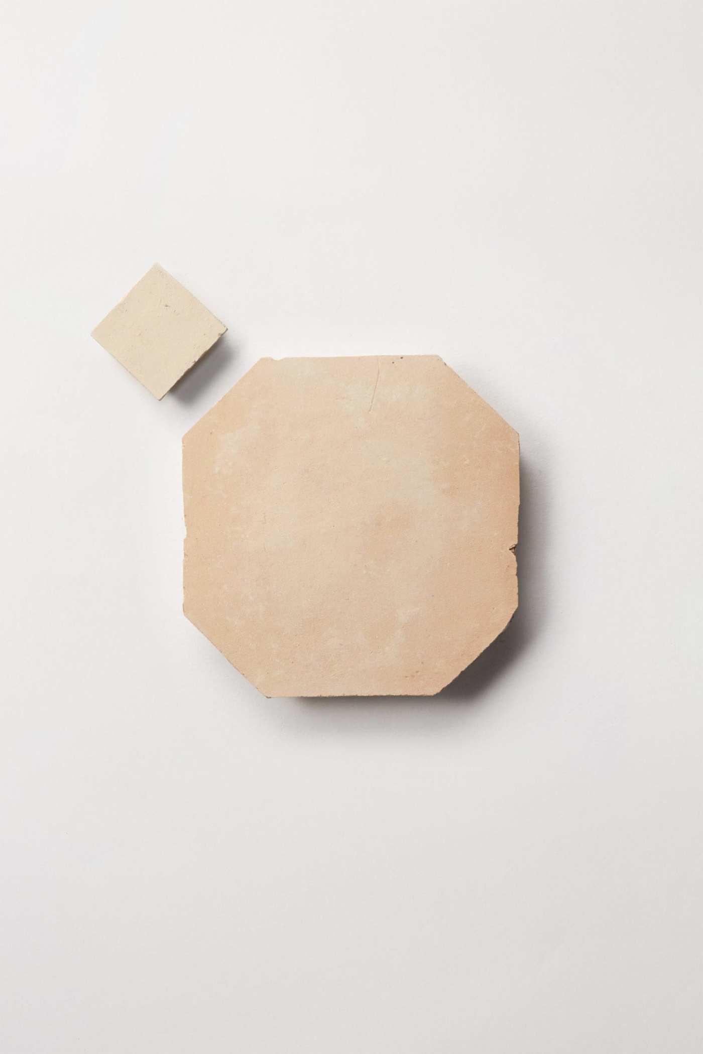 2 tan tiles on a white surface.