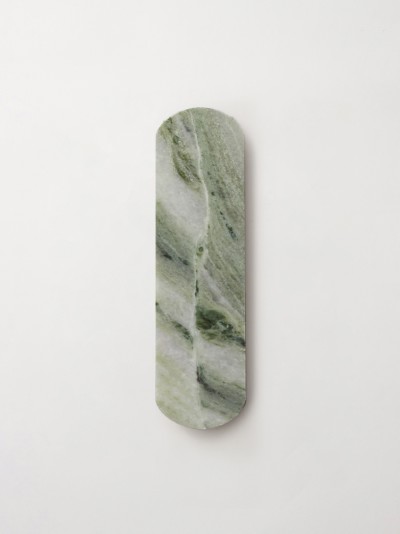 a piece of green marble on a white wall.