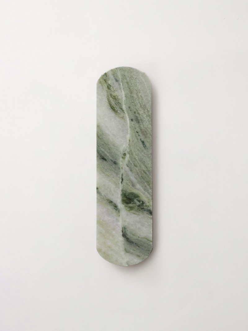 a piece of green marble on a white wall.