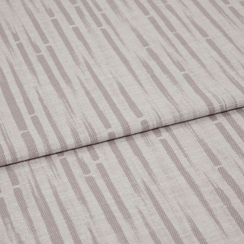 Patterned upholstery fabric (folded), pale mauve vertical dash stripes and textured weave; overlapping folded edge across the frame; close-up on a flat surface under soft, neutral lighting.