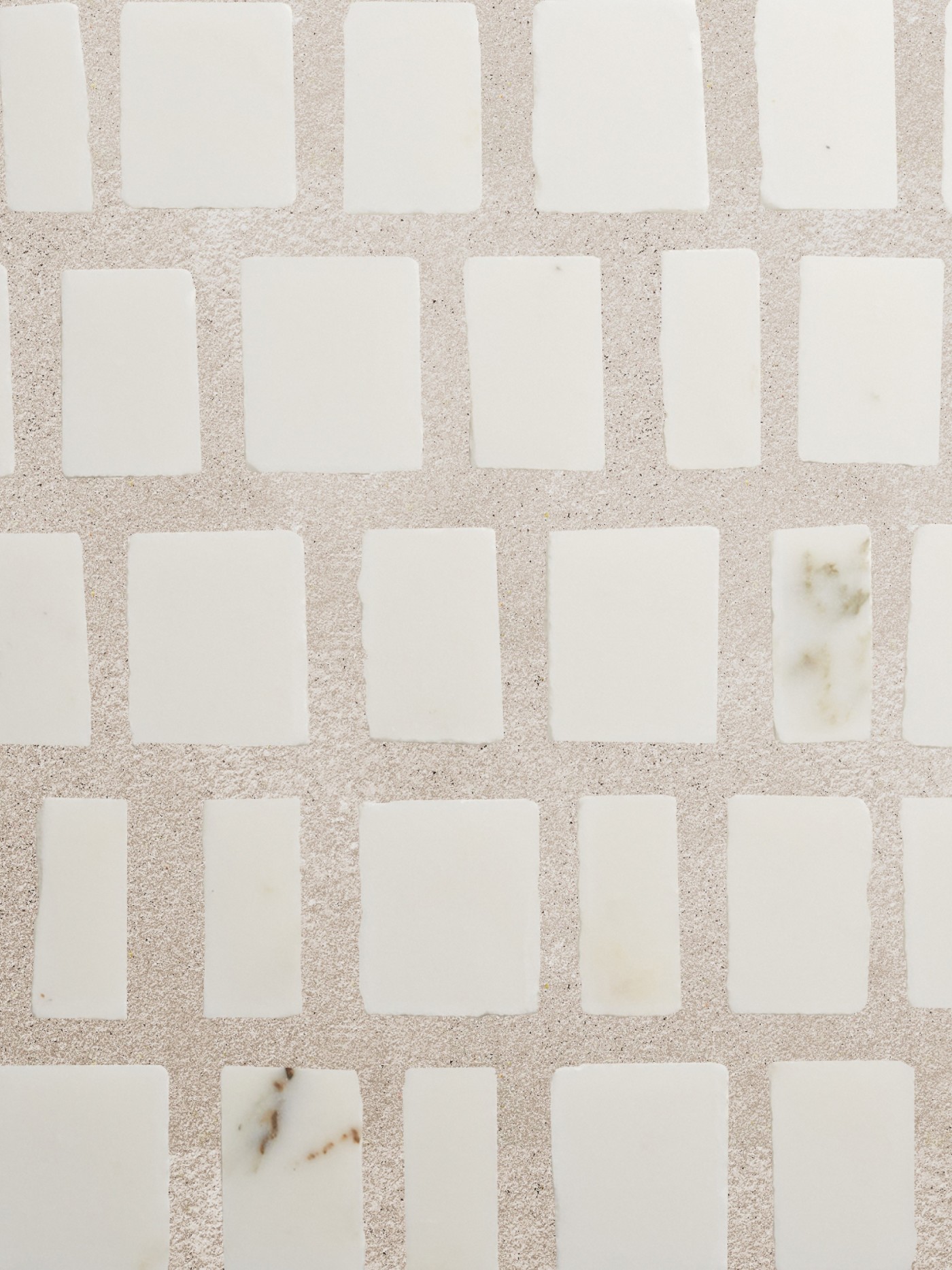 white marble mosaic tiles on a beige surface.