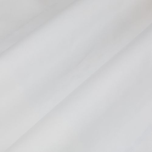 Sheer white curtain with diagonal soft folds draping across the frame, gently filtering daylight and casting subtle shadows in a bright, softly lit interior.