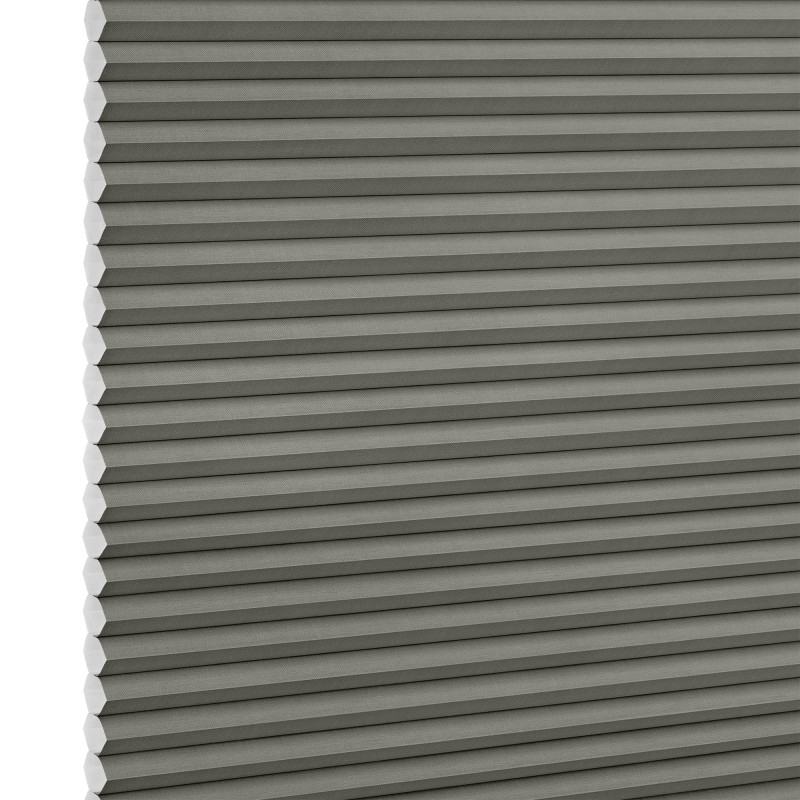 Grey honeycomb (cellular) pleated blind, vertically positioned with visible hexagonal cells at left edge; lowered and closed, evenly blocking light in a close-up, neutral studio-lit view.
