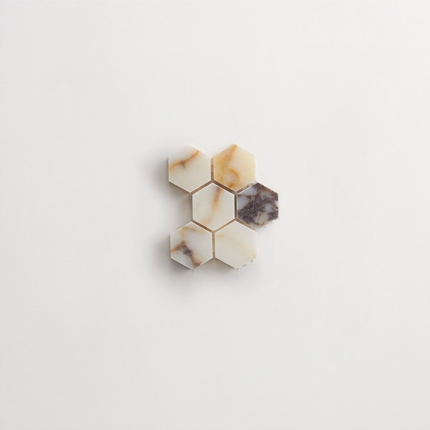 hexagonal pieces of marble on a white surface.