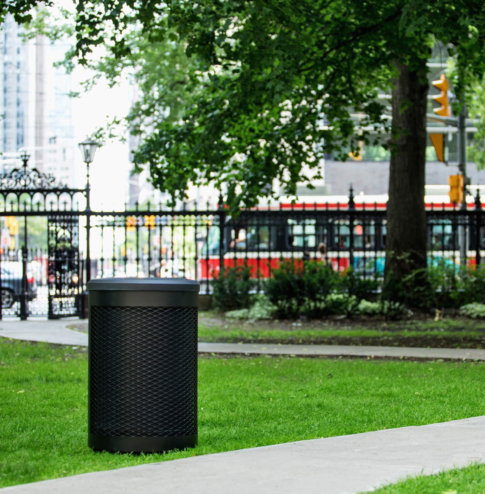 super durable all black metal and plastic waste bin in a city park area