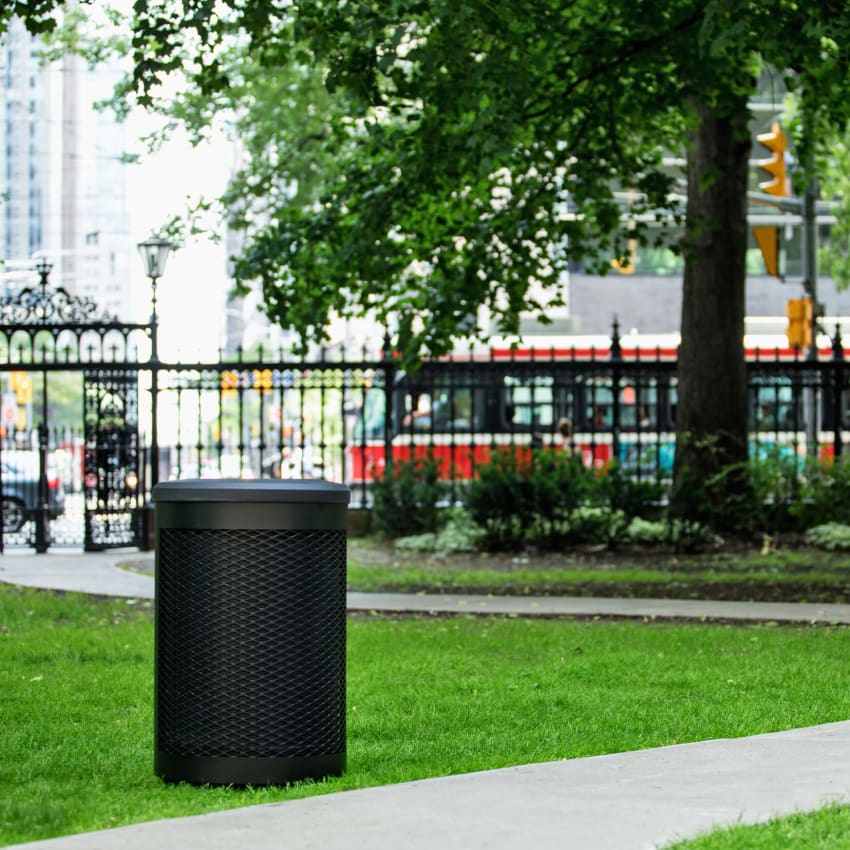 super durable all black metal and plastic waste bin in a city park area