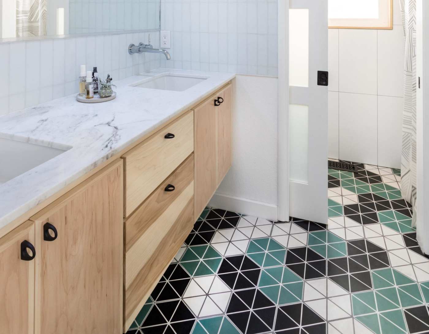 a bathroom with a green, black, and white tiled floor.