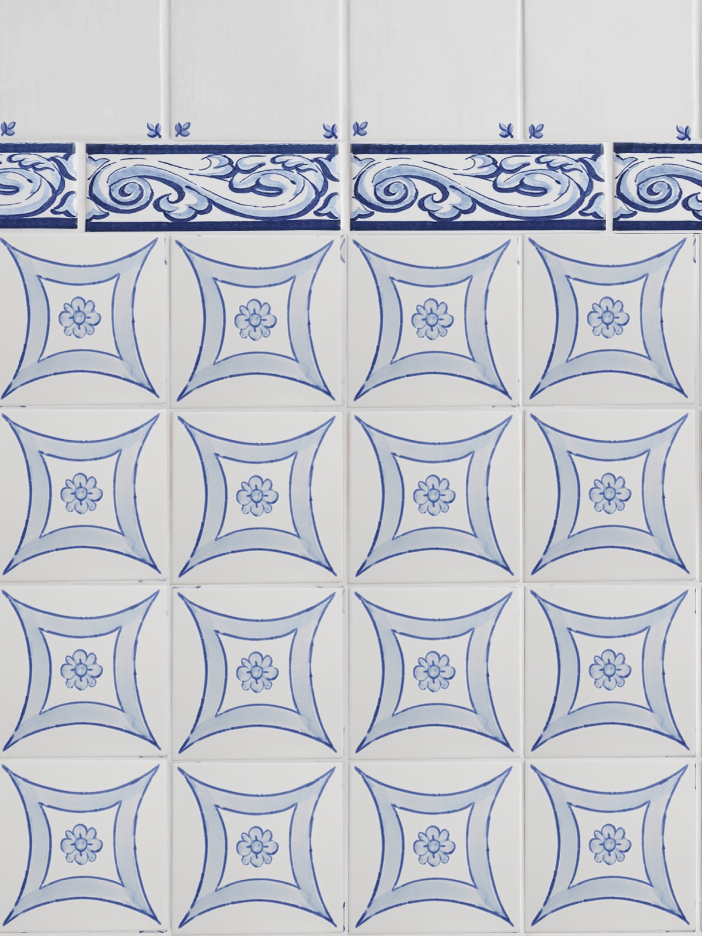 a blue and white tiled wall with designs on it.