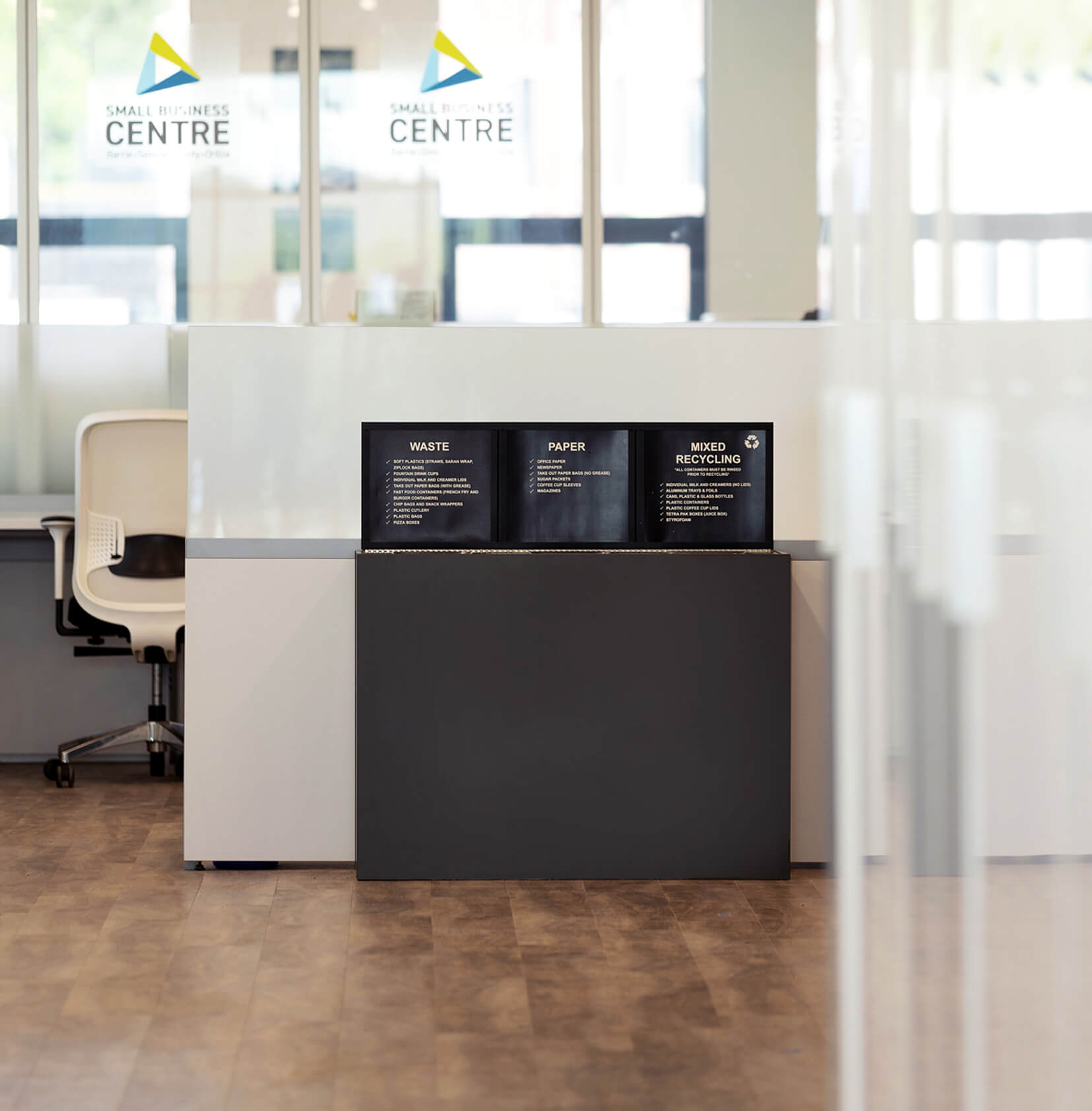 triple waste paper and recycling container in front of a business center with a sign frame