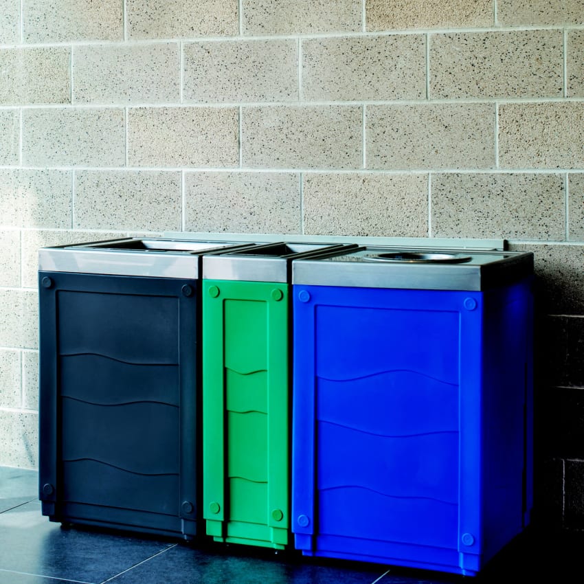 Trash and recycling station with color-coded bodies and pewter lids in a conference center foyer