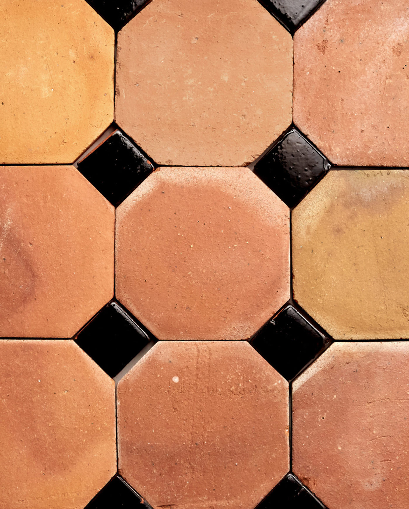 a close up of orange and black tiles arranged in a pattern.