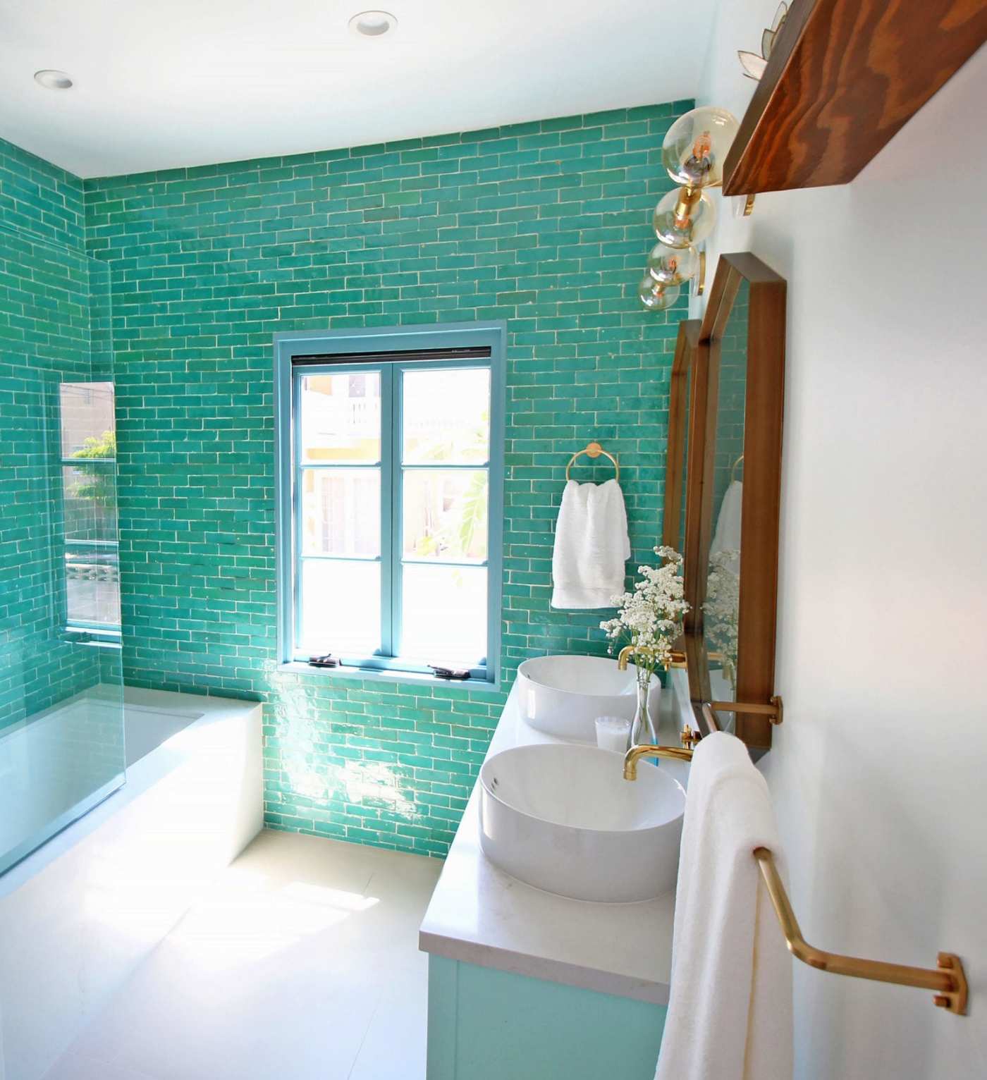 a bathroom with turquoise tiled walls.