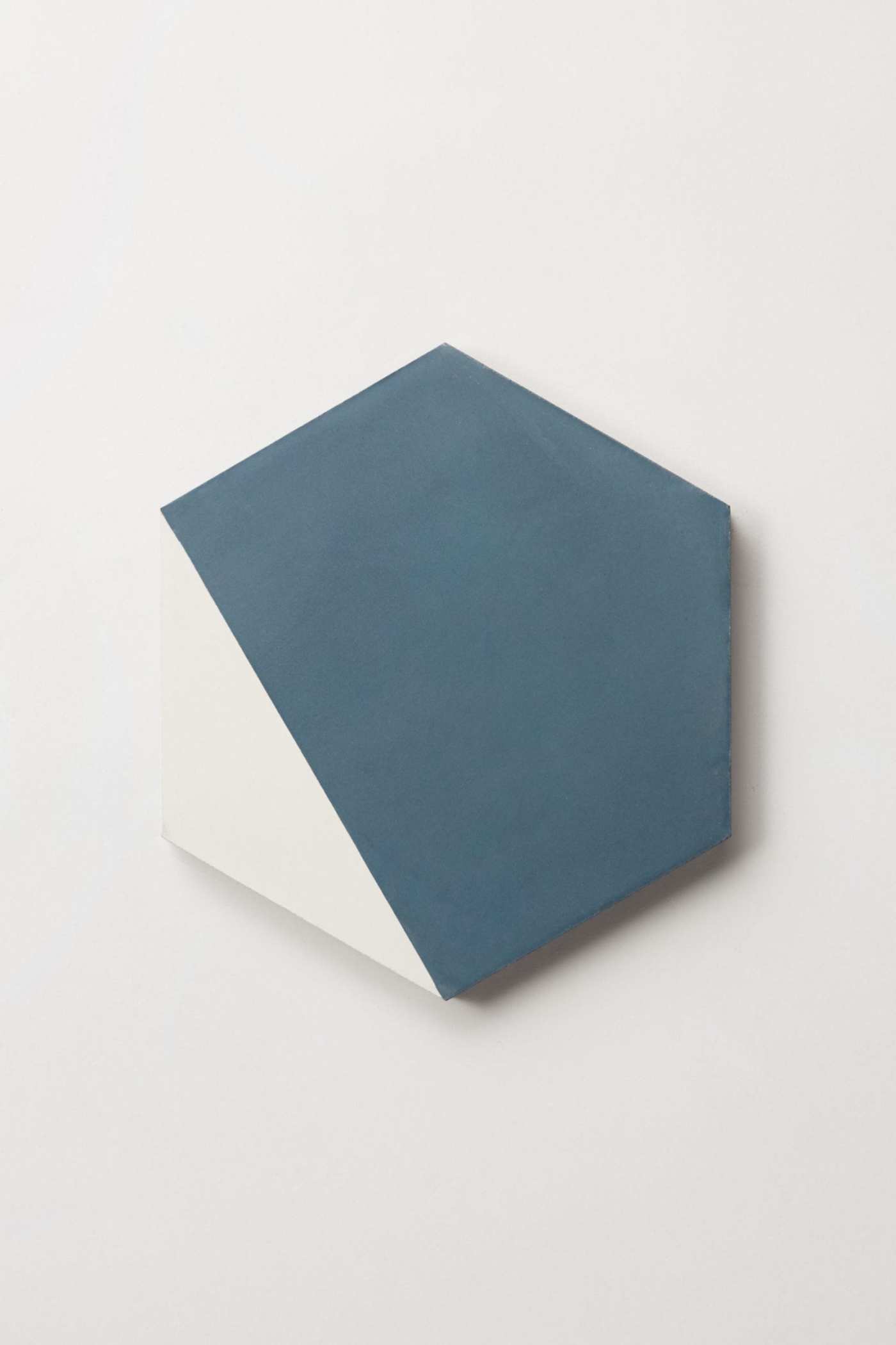 a blue and white hexagonal tile on a white surface.