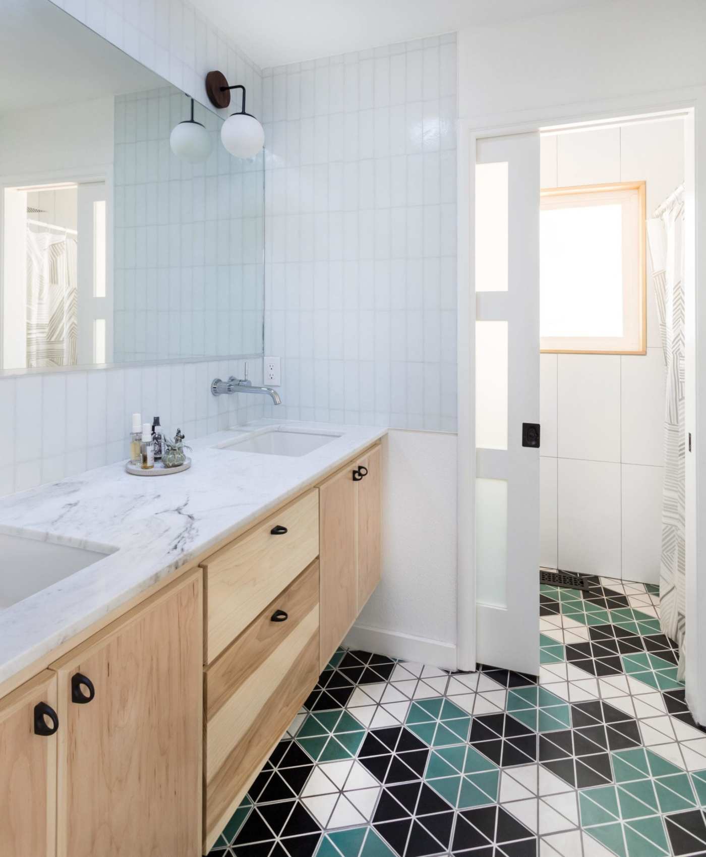 a bathroom with a green, black, and white tiled floor.