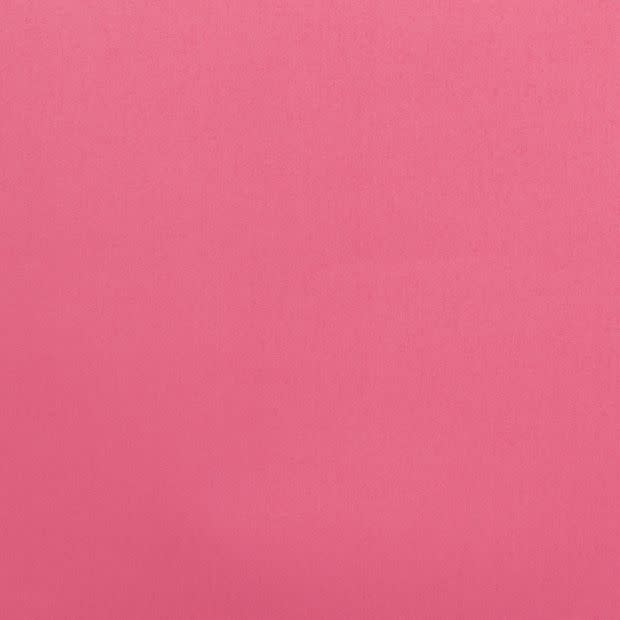 Solid pink textured fabric fills the frame, lying flat and evenly lit; no other objects or features are visible, producing a uniform matte backdrop with subtle weave texture.