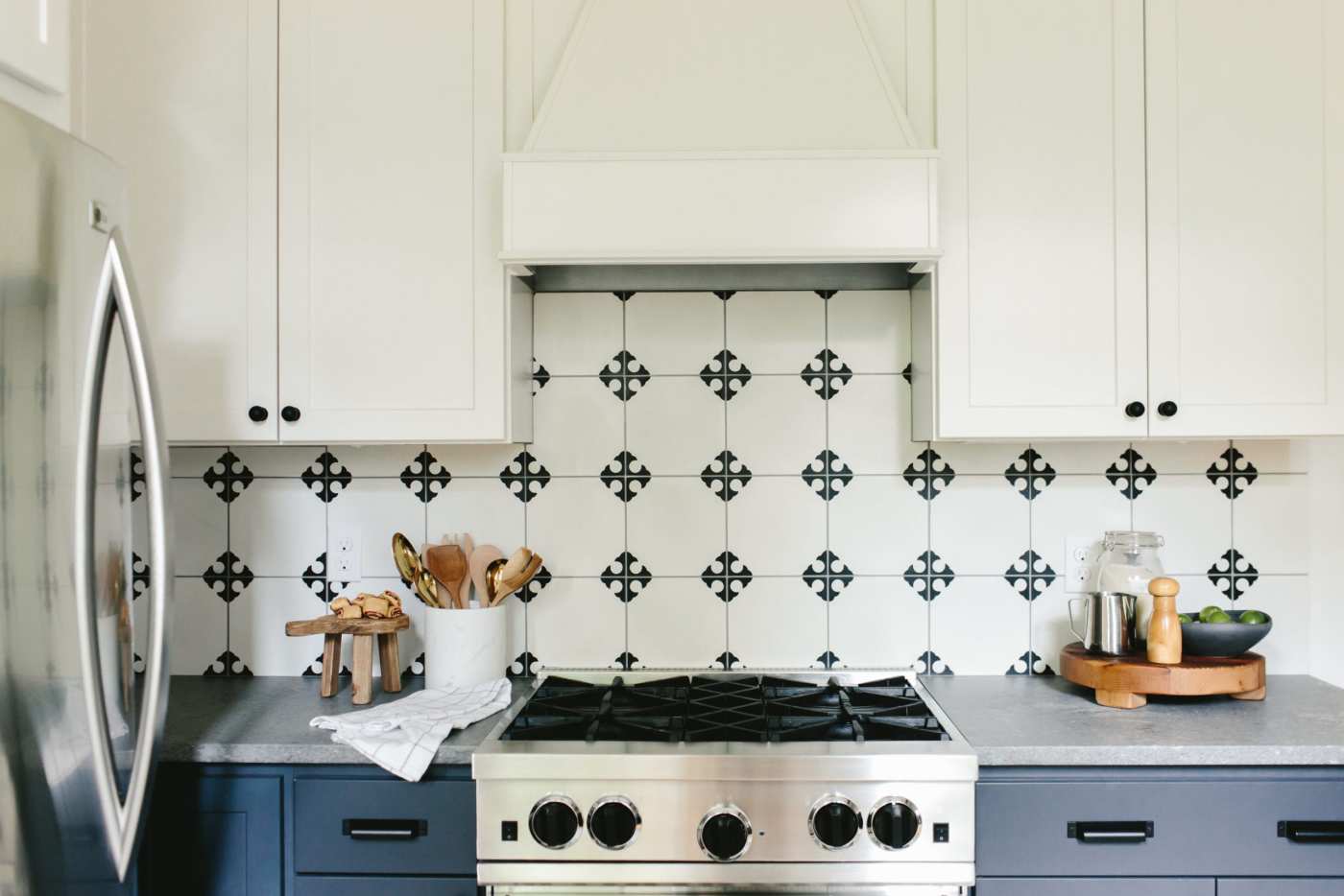 a kitchen with a black and white cross tiled stove backsplash.