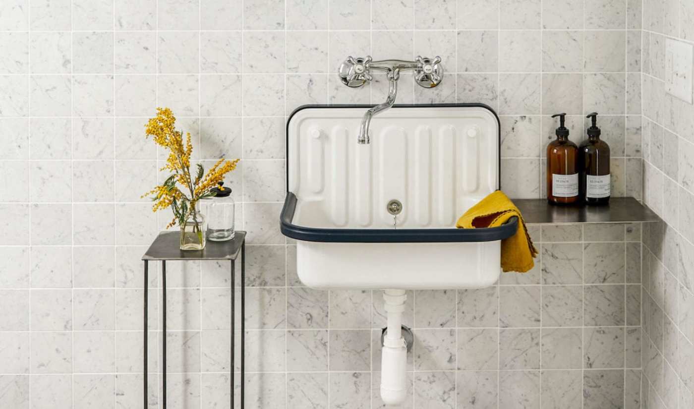 a bathroom with a white sink and a yellow flower.