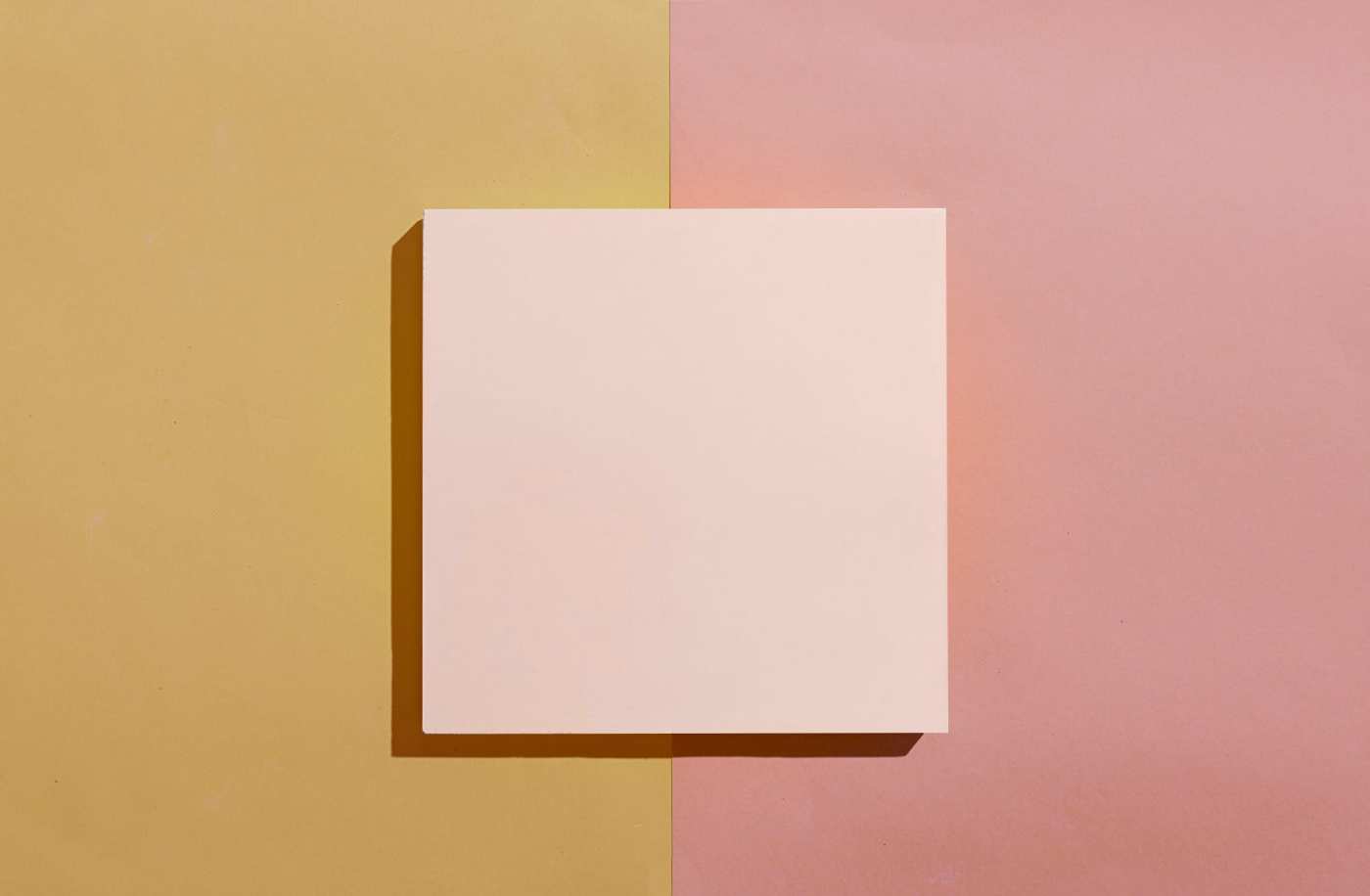 a square pink tile on a orange and pink surface.