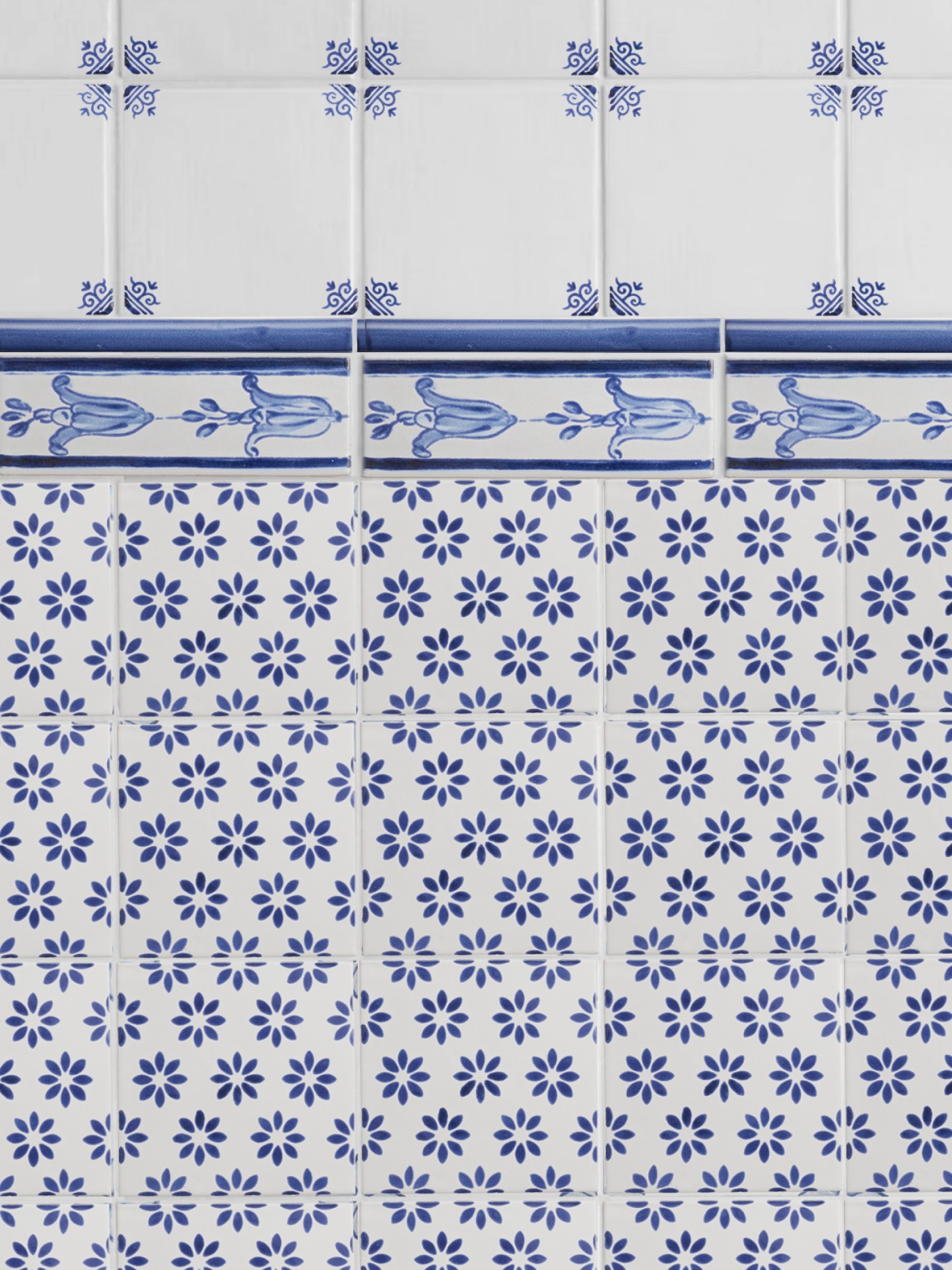 a blue and white tiled wall with floral designs.