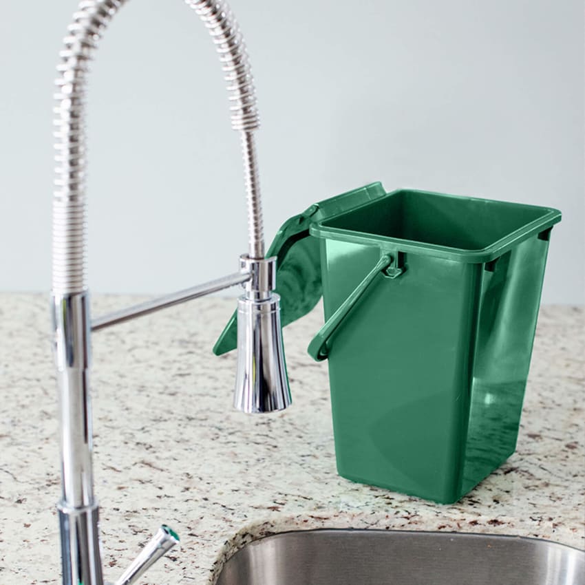 green kitchen organics collection bin sitting on a kitchen counter beside the sink with the lid open