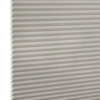 Light-gray pleated cellular window shade, closed with visible honeycomb cells and fabric texture; blocking light and insulating; shown close-up against a neutral, evenly lit backdrop.