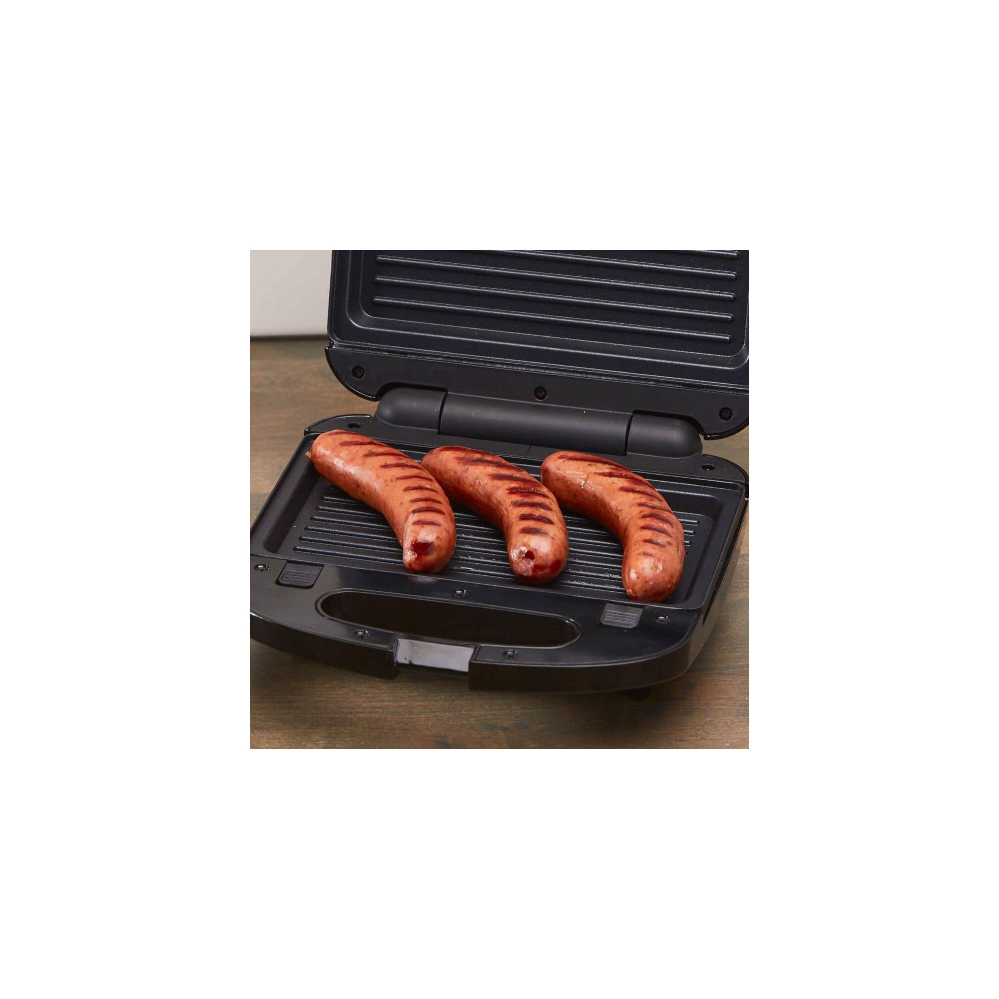 Waffle Maker Grill or Sandwich Maker with Stainless Steel Accents being used for grilling sausages.