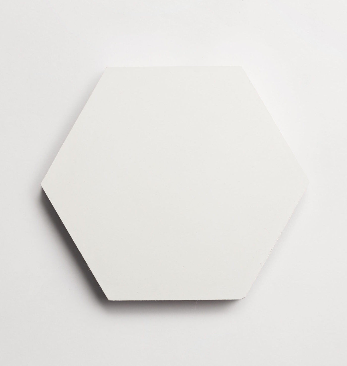 a white hexagonal tile on a white surface.